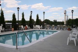 a swimming pool with white chairs and tables and chairs at Hampton Inn Stony Creek in Stony Creek