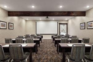 a classroom with tables and chairs and a projection screen at Homewood Suites Syracuse-Liverpool in Liverpool