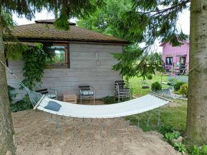 a hammock in a yard next to a house at Świerkowe Siedlisko pokoje gościnne in Węgorzewo