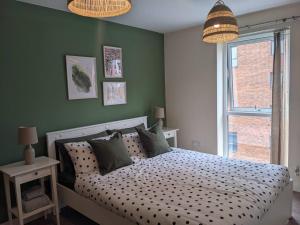 ein Schlafzimmer mit einem Bett und einer grünen Wand in der Unterkunft Homely 2 bed duplex with a river view in Southampton
