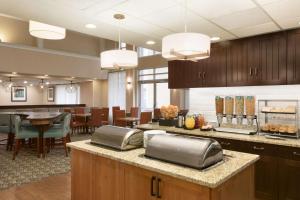 uma grande cozinha e sala de jantar com mesas e cadeiras em Homewood Suites by Hilton Toledo-Maumee em Maumee