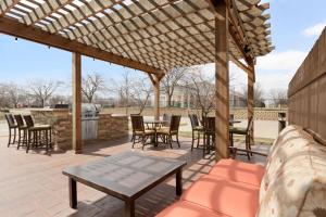 un patio con pergolato in legno, tavoli e sedie. di Homewood Suites by Hilton Toledo-Maumee a Maumee