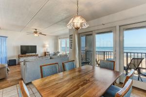 a living room with a table and chairs and a couch at Oceans Of Amelia - 309 in Fernandina Beach