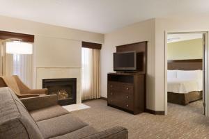 a living room with a couch and a television and a bed at Homewood Suites by Hilton Toledo-Maumee in Maumee