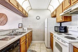 a kitchen with a sink and a refrigerator at Oceans Of Amelia - 309 in Fernandina Beach