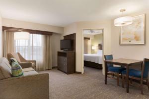 a hotel room with a bedroom with a bed and a desk at Homewood Suites by Hilton Toledo-Maumee in Maumee