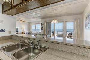 a kitchen with a sink and a view of the ocean at Oceans Of Amelia - 309 in Fernandina Beach