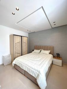 a bedroom with a large bed with a white bedspread at Oasis Mehdia vue sur mer in Kenitra