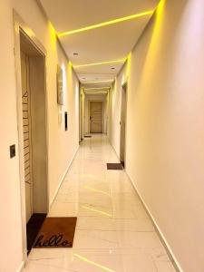 an empty hallway with yellow lights in a building at Oasis Mehdia vue sur mer in Kenitra