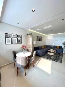 a living room with a table and a blue couch at Oasis Mehdia vue sur mer in Kenitra