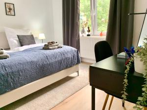 a bedroom with a bed and a desk and a window at Bright & central for 4 incl workspace in Bochum