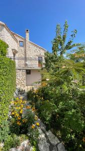 a house with a garden with flowers in front of it at Mountains Villa near Budva in Budva