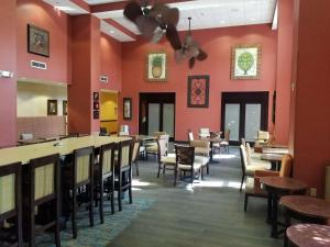 um restaurante com mesas e cadeiras e paredes vermelhas em Hampton Inn & Suites Tampa-Wesley Chapel em Wesley Chapel