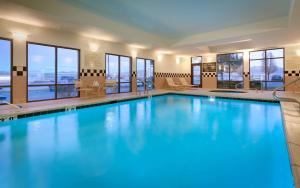 a pool with blue water in a hotel with windows at Hampton Inn Tremonton in Tremonton