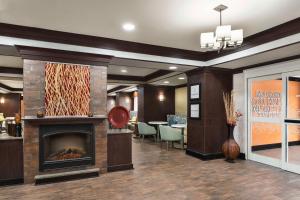a lobby with a fireplace and a dining room at Hampton Inn New Albany in New Albany