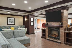a living room with a couch and a fireplace at Hampton Inn New Albany in New Albany