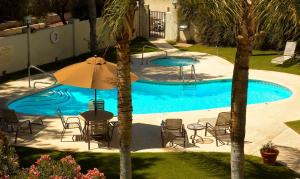 a pool with a table and chairs and an umbrella at Hampton Inn Tucson-Airport in Tucson