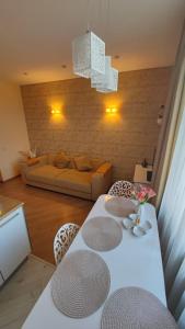 un salon avec une table et des chaises blanches dans l'établissement Baroness apartments, à Riga
