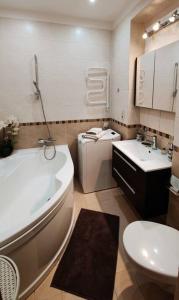 une salle de bains avec baignoire, toilettes et lavabo dans l'établissement Baroness apartments, à Riga