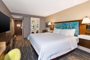 a hotel room with a large bed and a flat screen tv at Hampton Inn Traverse City in Traverse City