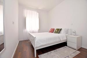 une chambre blanche avec un lit blanc et une fenêtre dans l'établissement Blue Harbour Luxury Apartment, Herceg Novi , Old Town, à Herceg-Novi