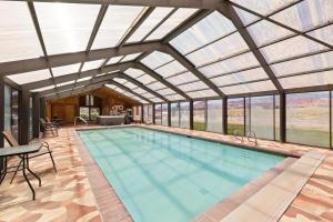 an indoor swimming pool with a glass ceiling at Broken Spur Inn & Steakhouse in Torrey