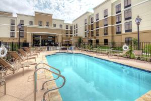 a swimming pool at a hotel with chairs and a building at Homewood Suites by Hilton Victoria in Victoria