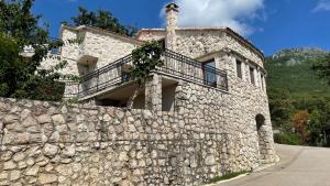 a stone building with a balcony on top of a stone wall at Mountains Villa near Budva in Budva