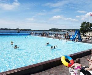 a large swimming pool with people in the water at Hytte med 4 Soverom in Kristiansand