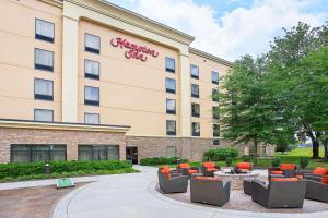 a hotel with chairs and tables in front of a building at Hampton Inn Knoxville-West At Cedar Bluff in Knoxville