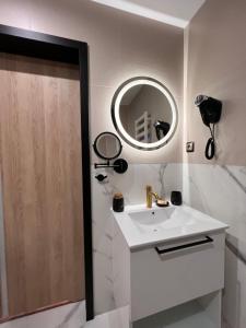 a bathroom with a sink and a mirror at Resto Inn - Smart apartamenty blisko Energylandii in Po”łwieś
