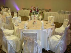 einen Tisch mit weißen Tischen und Stühlen in einem Zimmer in der Unterkunft Hilton Garden Inn Victorville in Victorville