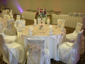 a table with white tables and chairs in a room at Hilton Garden Inn Victorville in Victorville