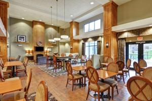 Hampton Inn and Suites New Hartford/Utica في New Hartford: مطعم فيه طاولات وكراسي في الغرفة