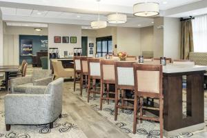 a hotel lobby with a bar and chairs at Hampton Inn Philadelphia/Voorhees in Voorhees