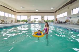 a woman and a baby in a swimming pool at Hampton Inn Uniontown in Uniontown