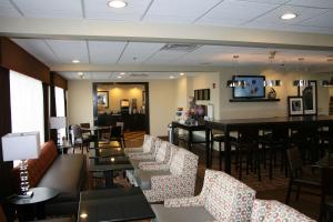 a restaurant with couches and tables and a bar at Hampton Inn Uniontown in Uniontown