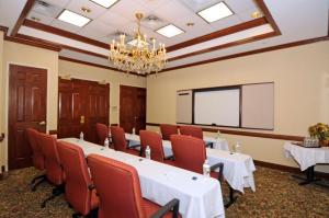 une salle de conférence avec des tables et des chaises et un écran de projection dans l'établissement Hampton Inn Alexandria/Old Town, à Alexandria