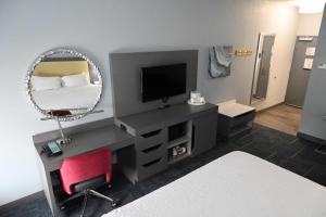 a room with a bed and a mirror and a chair at Hampton Inn Valdosta/Lake Park Area in Lake Park