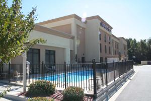 a fence in front of a house with a pool at Hampton Inn Vidalia in Vidalia