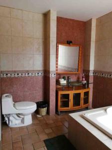 a bathroom with a toilet and a sink and a mirror at Casa Lídxi Beexha in Santa María Azompa