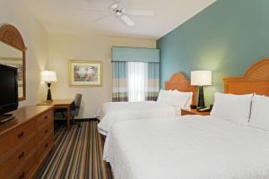 a hotel room with two beds and a flat screen tv at Hampton Inn & Suites Venice Bayside South Sarasota in Venice
