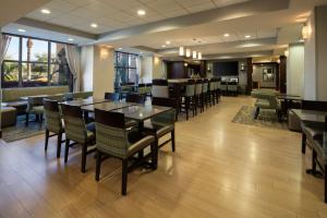 a restaurant with tables and chairs and a bar at Hampton Inn Visalia in Visalia