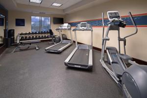 einen Fitnessraum mit Laufbändern und Crosstrainern in einem Zimmer in der Unterkunft Hampton Inn Visalia in Visalia