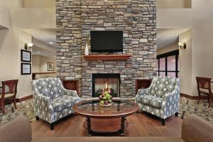 sala de estar con 2 sillas y chimenea en Hampton Inn & Suites Enid, en Enid