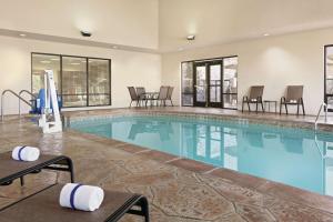 uma piscina num hotel com cadeiras e mesas em Hampton Inn & Suites Enid em Enid