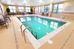 a pool in a hospital with tables and chairs at Hampton Inn Waynesburg in Waynesburg