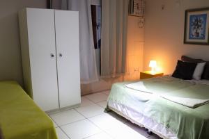 um quarto com uma cama e um armário branco em Hostel Cristo Da Barra em Salvador