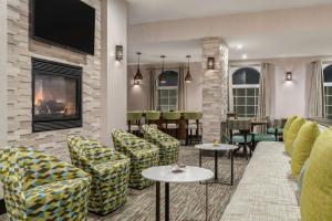 a hotel lobby with chairs and tables and a tv at Homewood Suites by Hilton Providence-Warwick in Warwick