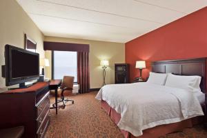 a hotel room with a bed and a flat screen tv at Hampton Inn Winfield Teays Valley in Teays Valley Estates